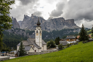 Fototapeta na wymiar Clouds over the church in Dolomites