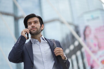 Walking business man with briefcase. businessman using smartphone in city street.