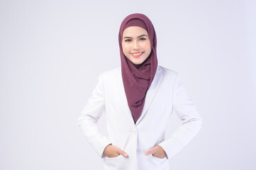 Beautiful muslim business woman wearing white suit with hijab in studio.