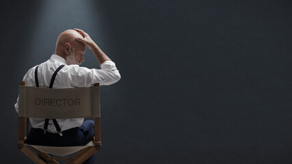 Disappointed filmmaker sitting on the director's chair