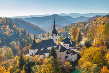 The Spania Dolina village with church and historic buildings in valley of autumn landscape, Slovakia, Europe.