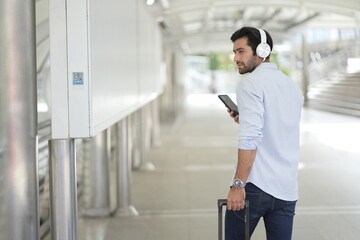 Traveler Man on smart phone - young man in airport. Casual urban professional businessman using smartphone Handsome Caucasian Man Relaxing With Smartphone While Waiting For Flight In Airport.