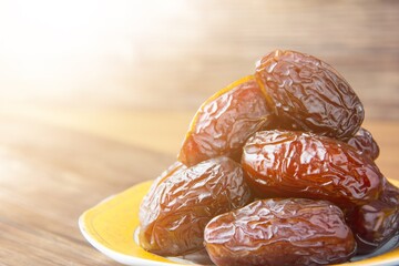 Delicious medjool dates ( kurma ) or sweet dried dates on a plate, as a meal for breaking the fast,...