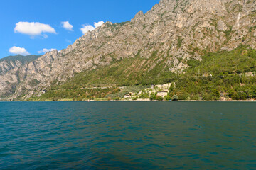 The beautiful Garda lake in Italy, seen from onboard a tourist ferry. It is a beautiful summer day, with just a little bit of clouds.