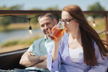 Fototapeta premium a young happy couple is enjoying a hot summer day sitting on the terrace of a restaurant