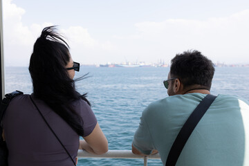 Back view of man and woman talking by sea. Unrecognizable person.