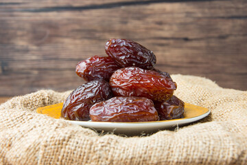 Delicious medjool dates ( kurma ) or sweet dried dates on a plate, as a meal for breaking the fast, ramadan kareem, empty space, copy space.
