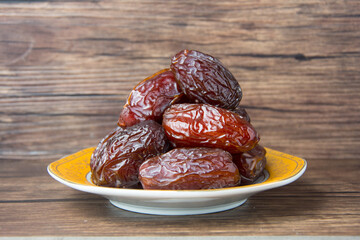 Delicious medjool dates ( kurma ) or sweet dried dates on a plate, as a meal for breaking the fast, ramadan kareem, empty space, copy space.