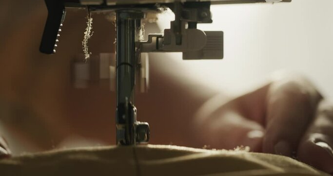 Detail of a sewing machine close-up. Needle sews fabric