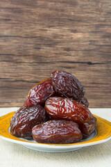 Delicious medjool dates ( kurma ) or sweet dried dates on a plate, as a meal for breaking the fast, ramadan kareem, empty space, copy space.