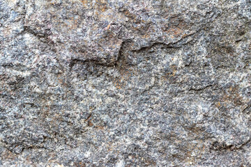 Texture of a stone wall with cracks and scratches which can be used as a backgr. The texture of the stone.