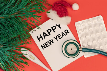 happy new year is written in the notebook. Medical supplies and Christmas decorations. The concept of congratulations for doctors