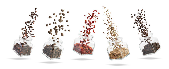 different spices fly out of glass jars on a white background. Falling spices.