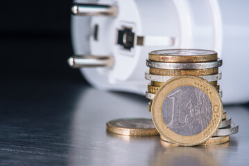Euro coins and electrical plug, concept of inflation and increasing energy prices