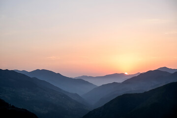 Smoky mountain sunset.Majestic autumn scenery of foggy valley at mountain range at early morning sunrise. Beautiful tonal perspective wide angle panorama