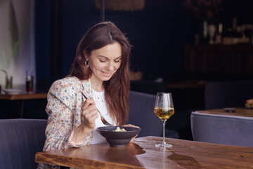 girl eating salad with wine close-up in a modern restaurant