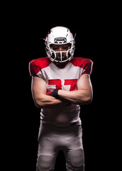 Male American football player crosses his arms in kit.