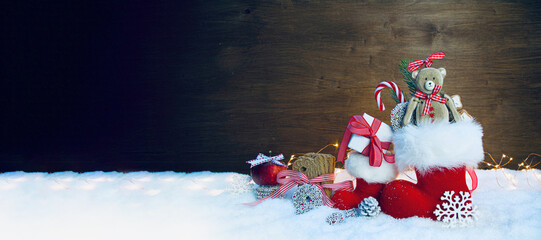 Santa Claus boot with toys and gift box in snow - Stuffed Santas shoe - Christmas background banner...