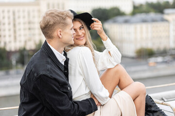 Beautiful happy young loving couple on a surprise date on a Saint Valentine's Day. Romantic modern wedding on the rooftop, summertime. Young man and beautiful girl. Newlyweds on honeymoon