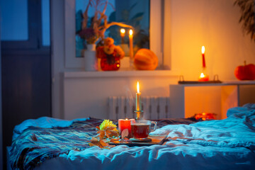 cup of tea with burning candles in bedroom