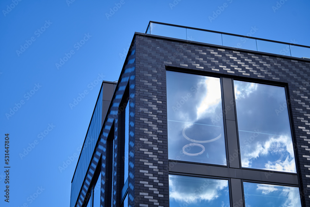 Poster office building against the sky. reflection of the blue sky and clouds in the windows of the structu