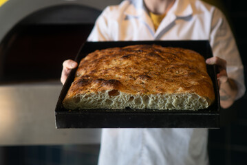 baker holding focaccia