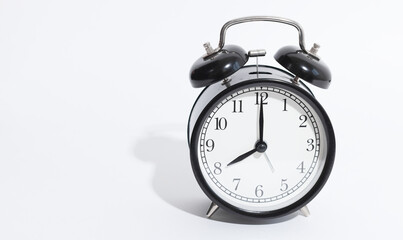 black vintage style alarm clock isolated on a white background