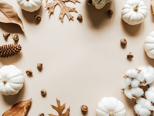 Fall composition with different leaves, pumpkins, acorns on beige background.