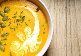Yellow Pumpkin Soup on wooden background. Close up. Top view.