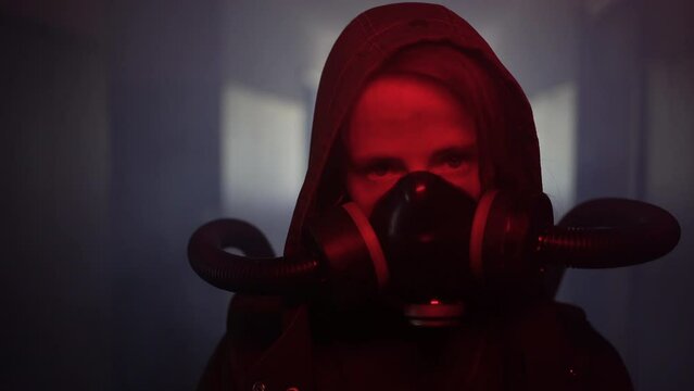 Environmental disaster concept. Post-apocalyptic survivor in gas mask on a dark background. Dramatic portrait of a woman wearing a mask. Means for radiation protection. Radiation war.