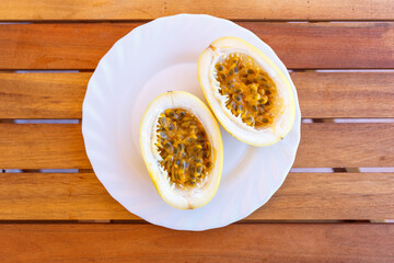 Top view of cut in half passion fruit served on white plate