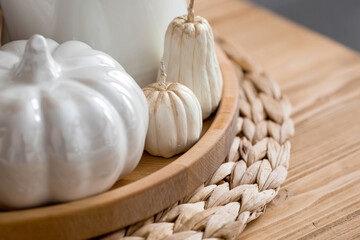 Still-life. White ceramic pumpkins, pampas grass, pumpkin-shaped candles on the coffee table in the home interior of the living room. Details of the decor. Cozy autumn concept.