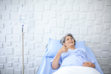 An elderly woman thumbs up and smiling as the doctor examines the condition in the recovery room. Healthcare and medicine concept. - 531461241