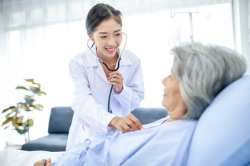 Fototapeta premium Beautiful asian doctor with stethoscope and document folder, examine the symptom for patient in the recovery room. Healthcare and medicine concept.