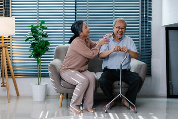 Happy Life Retirement and Healthcare Concept, Asian Senior wife take care her husband, Elderly couple sitting on couch in living room with love