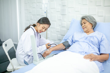 Obraz premium Asian doctor is measuring blood pressure and checking pulse senior patient, Healthcare and medicine concept.