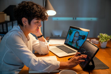 woman working at a desk in her office at night using a laptop