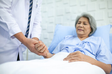 Obraz premium Asian doctor supporting and cheering up senior patient in hospital, talking smiling in comfort. Healthcare and medicine concept.