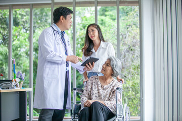 Fototapeta premium Asian doctor explaining illness to senior patient with tablet smiling in comfort at home, Healthcare and medicine concept.