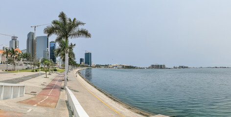 Panoramic view at the Luanda bay and Luanda marginal, pedestrian pathway with tropical palm trees,...