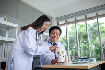 group of doctors study the physiology of the human body with bone model.