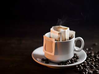 A white cup of freshly brewed drip coffee. Steam from hot coffee