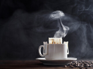 A white cup of freshly brewed drip coffee. Steam from hot coffee