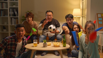 Happy asian friends or football fans watching soccer on tv and celebrating victory at...