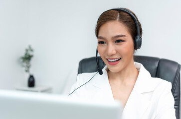 Asian woman Call center agent with headset working on support hotline in modern office.