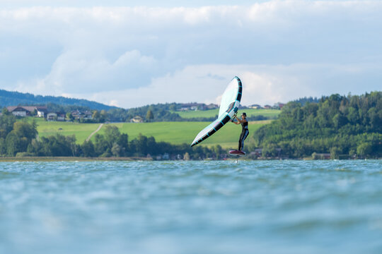 Woman wing foiling on lake Wallersee, Salzburg, Austria