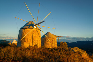 Old stone windmills in the mountains. Landscape with windmills at sunset