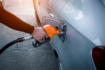 Refueling oil car at Gas Station, pump, hand of man refilling gasoline being pumped into the motor,...
