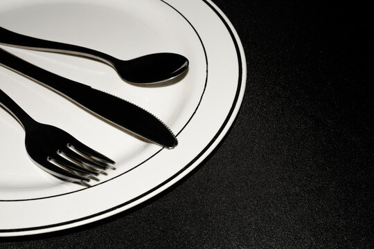 tablespoon ,knife ,fork on flat plate on black background