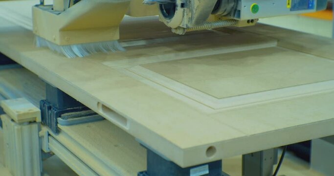 furniture production.working industrial equipment close-up.modern cnc machine processes wood panel.